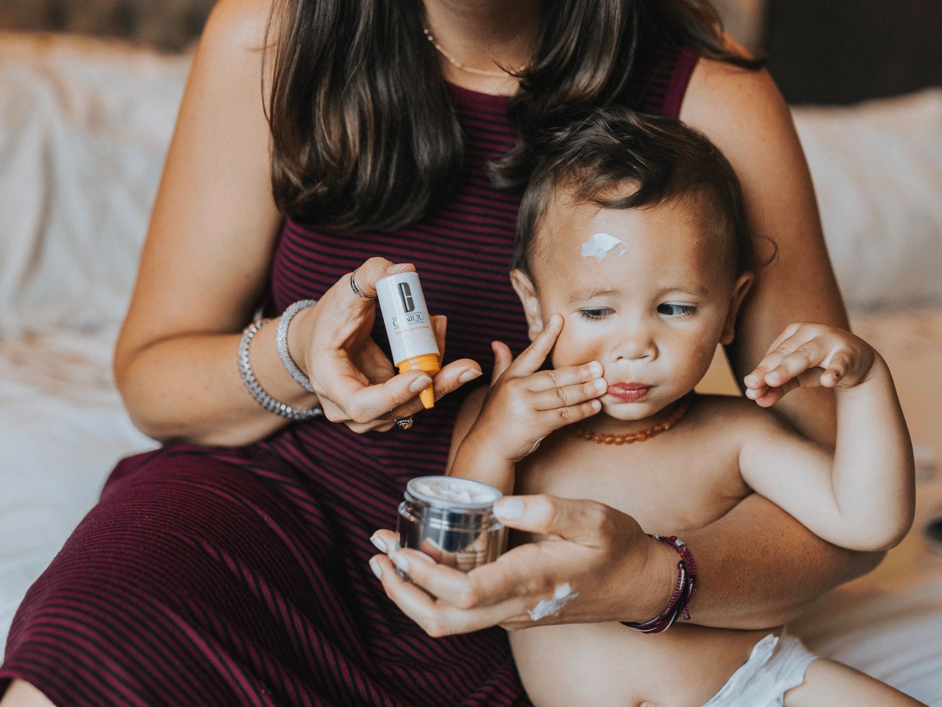 toddler playing with moms beauty products