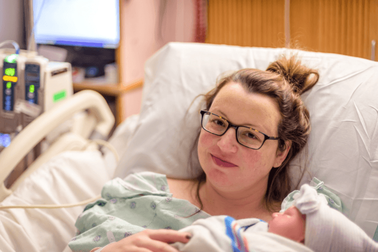 mom holding newborn in a hospital bed