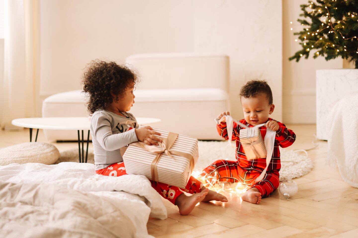 two young children opening one gift each on Christmas morning