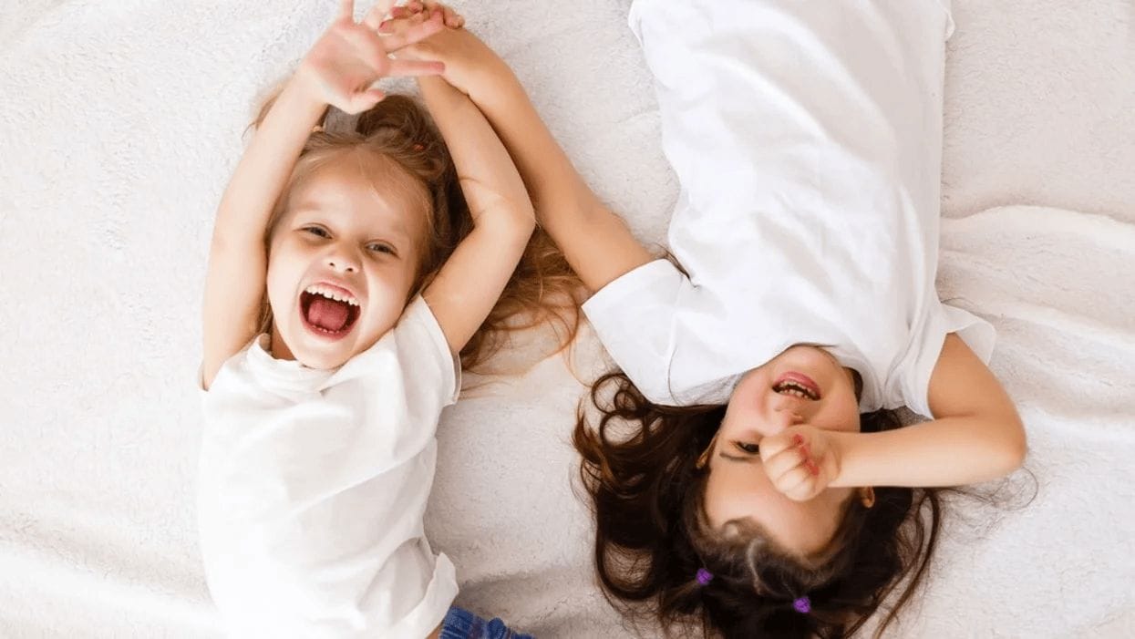 sisters playing on a bed together