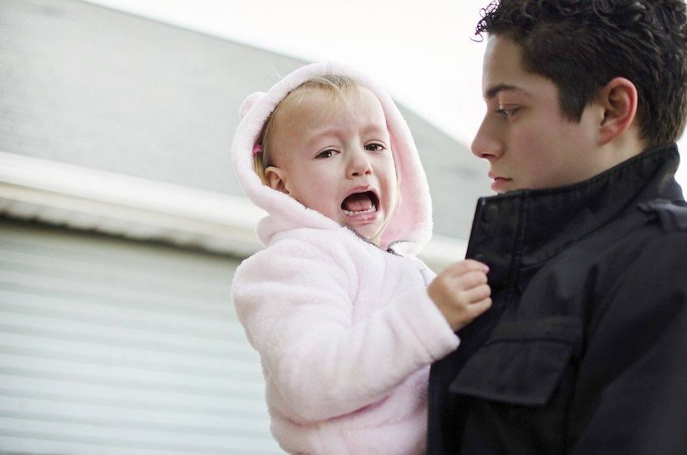 dad holding a screaming toddler