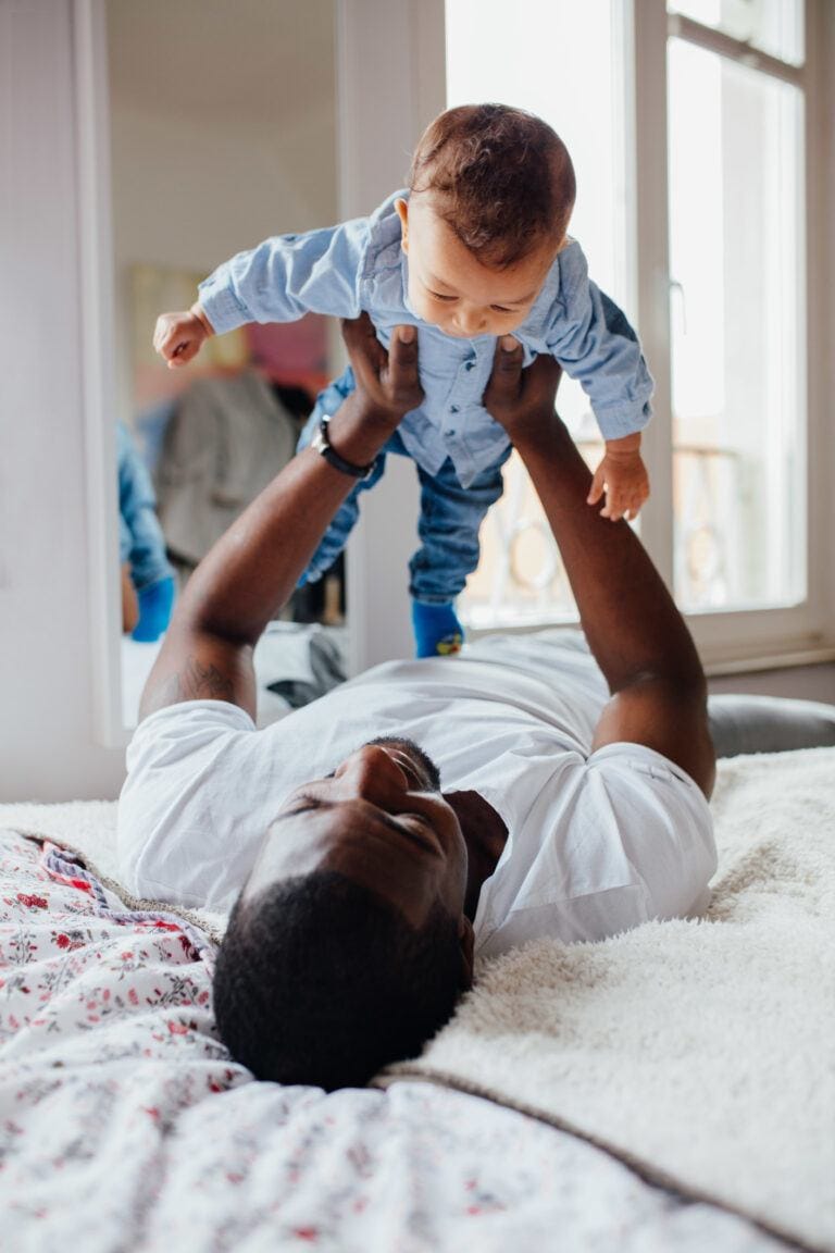 dad playing with baby in the air