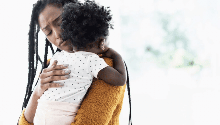 mom comforting baby on shoulder