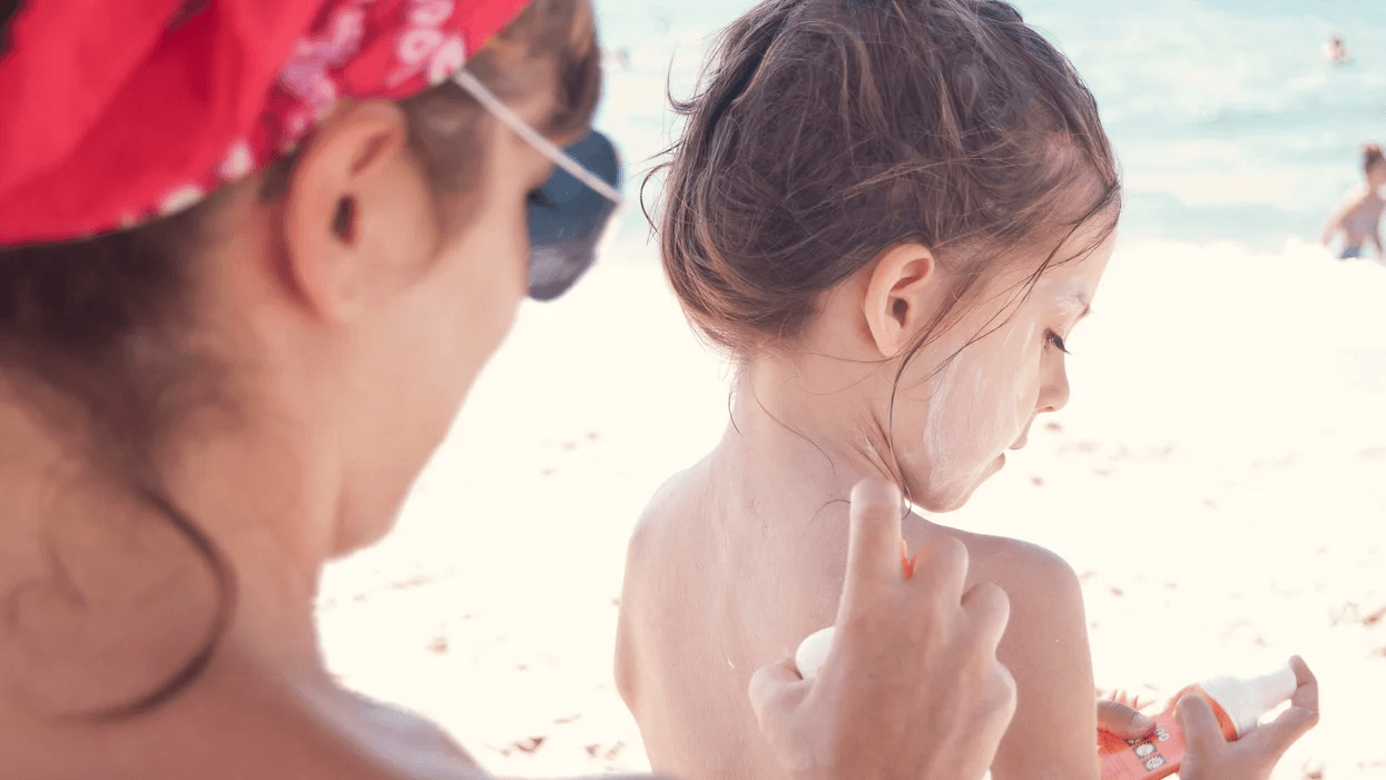 mom putting sunscreen on a little girl