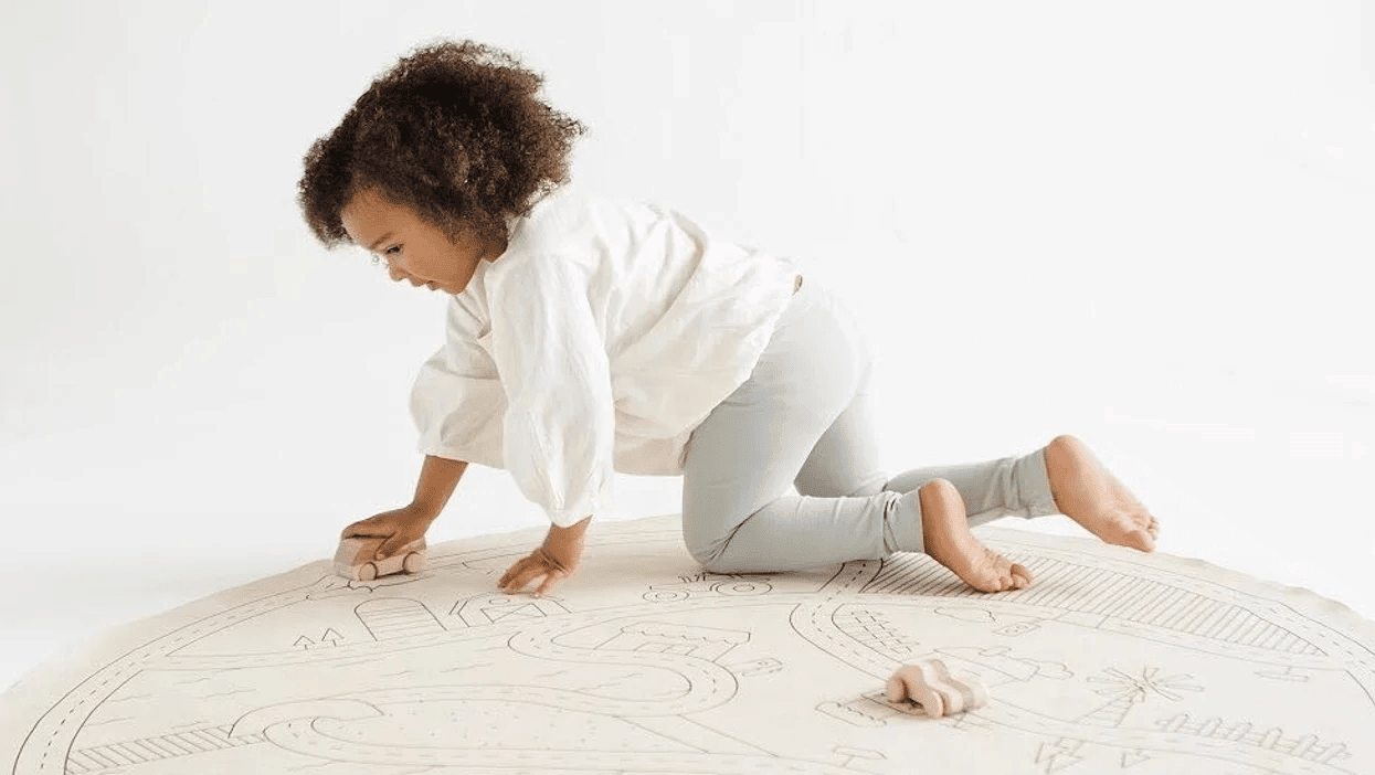 little girl playing on a gathre mat