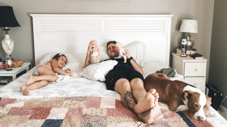 dad sitting in bed with kids