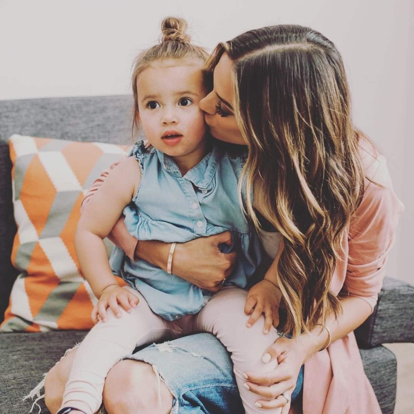 mom kissing daughter's cheek