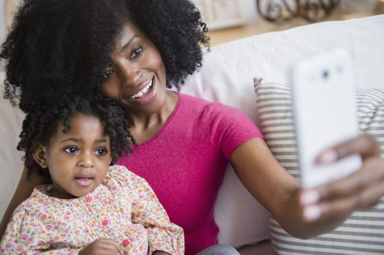 mom and her daughter holding a phone