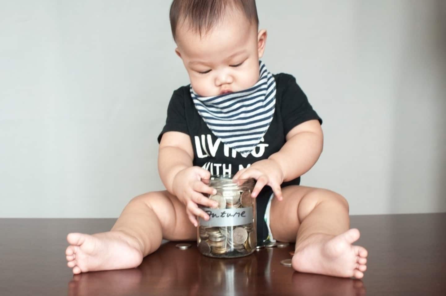 baby holding a jar full of coins