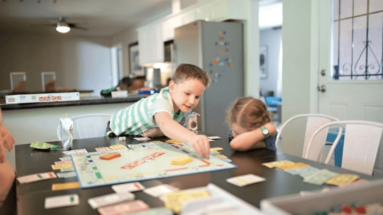 kids playing monopoly at a table