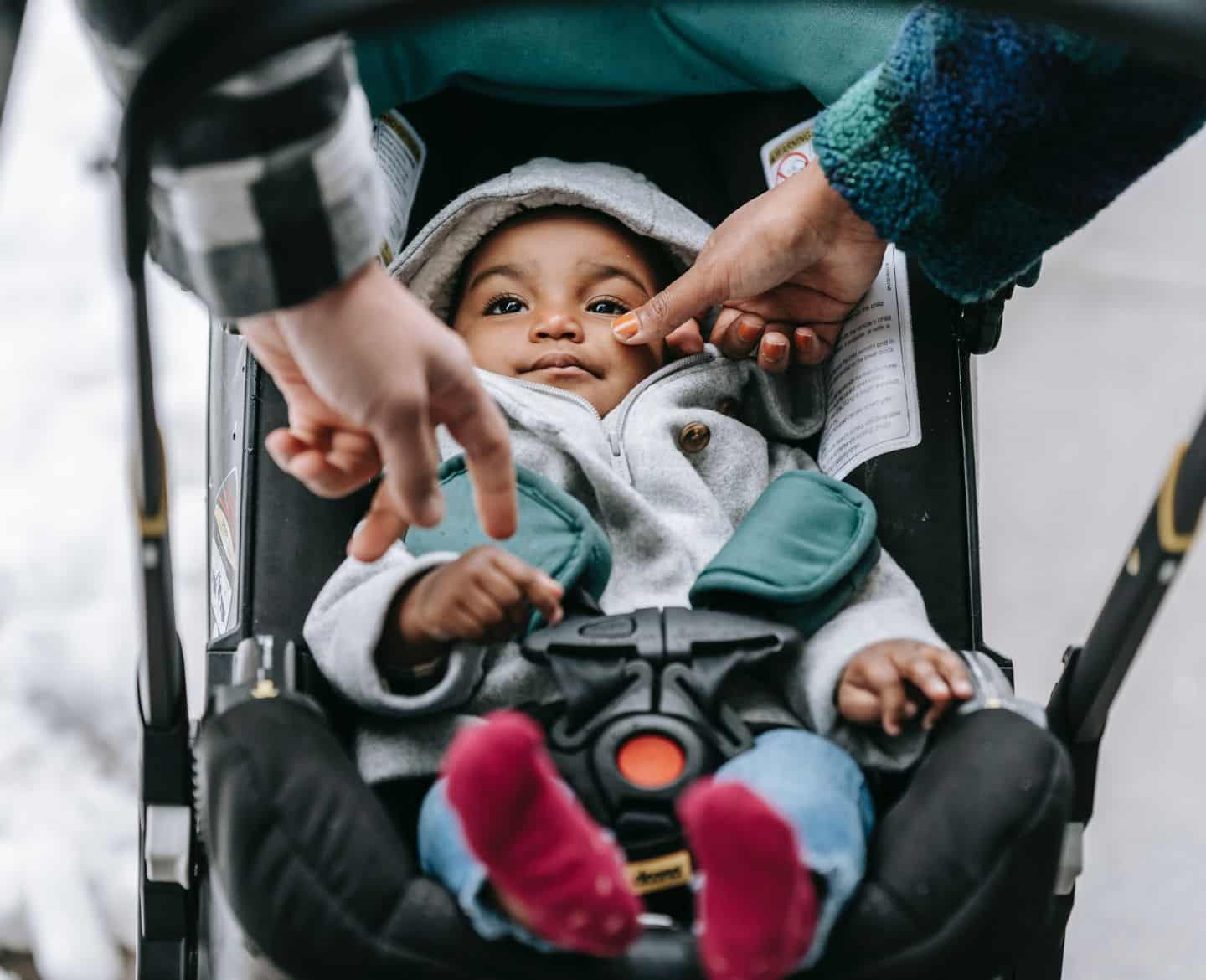 parents poking baby in his stroller