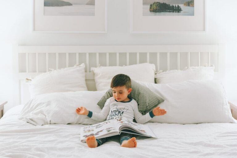 child reading a book on the bed