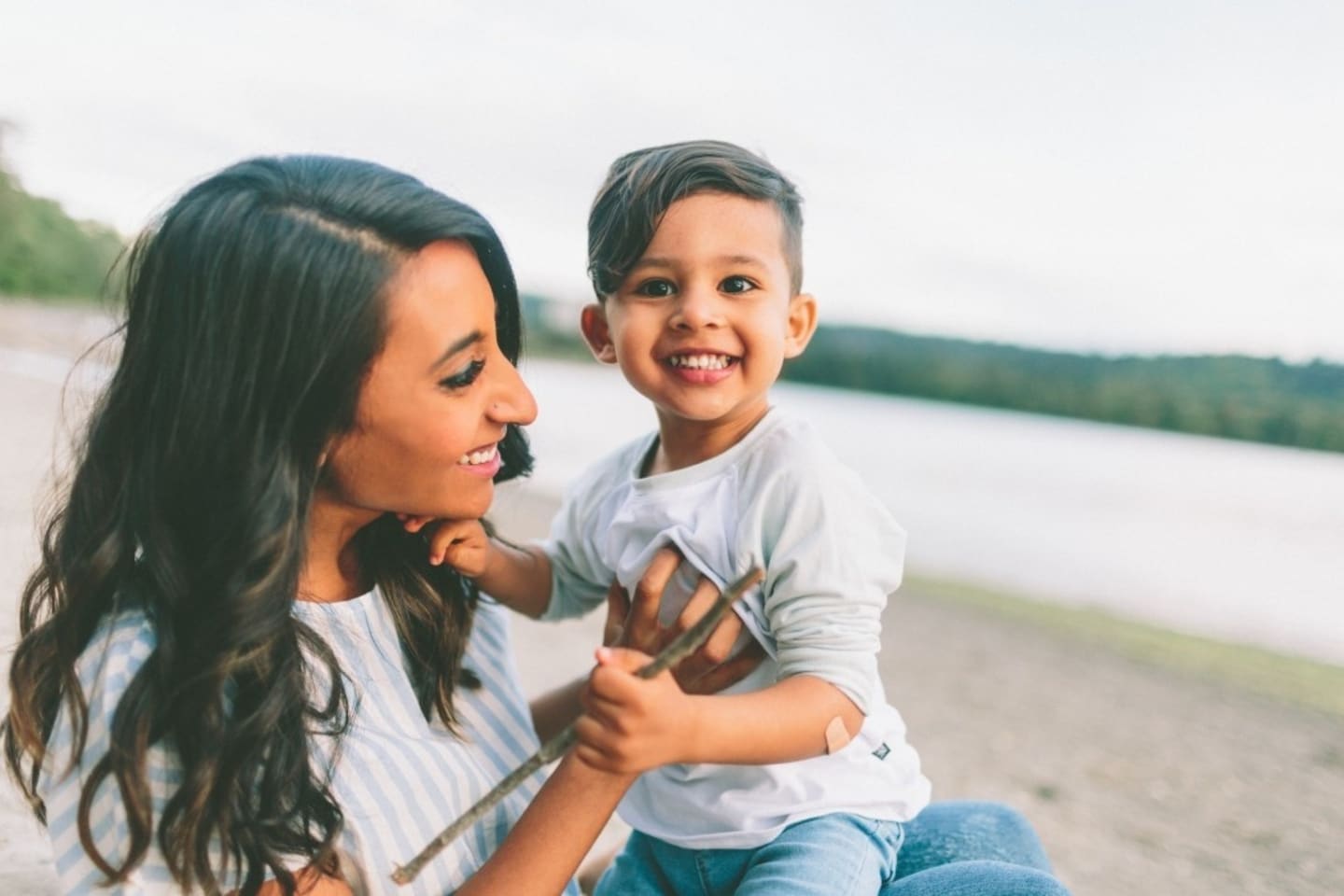 mother holding her child on her lap, using rie parenting methods to foster its capacity to learn