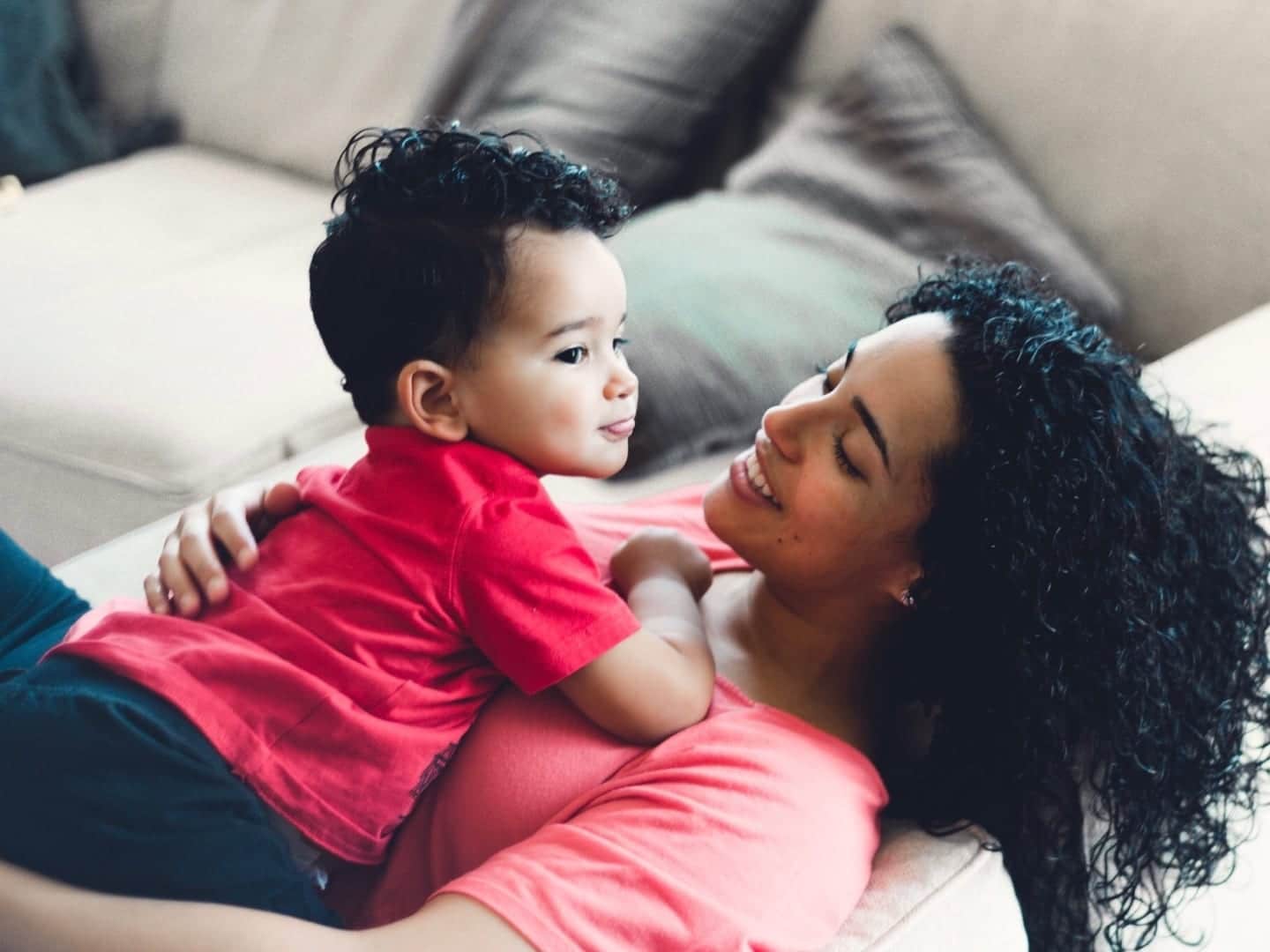 growth mindset in kids: mother holding toddler son on chest while sitting on couch