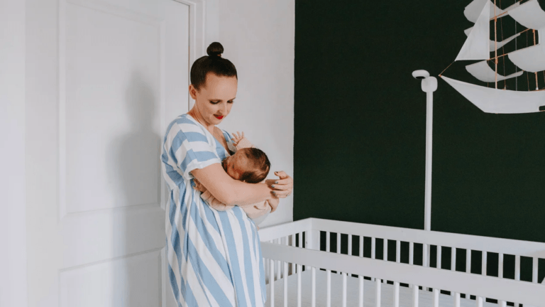 mom holding baby in nursery