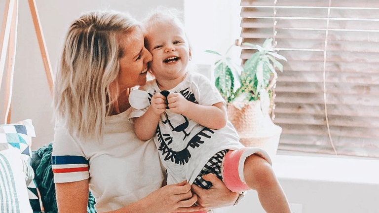 mom holding a toddler with a leg cast