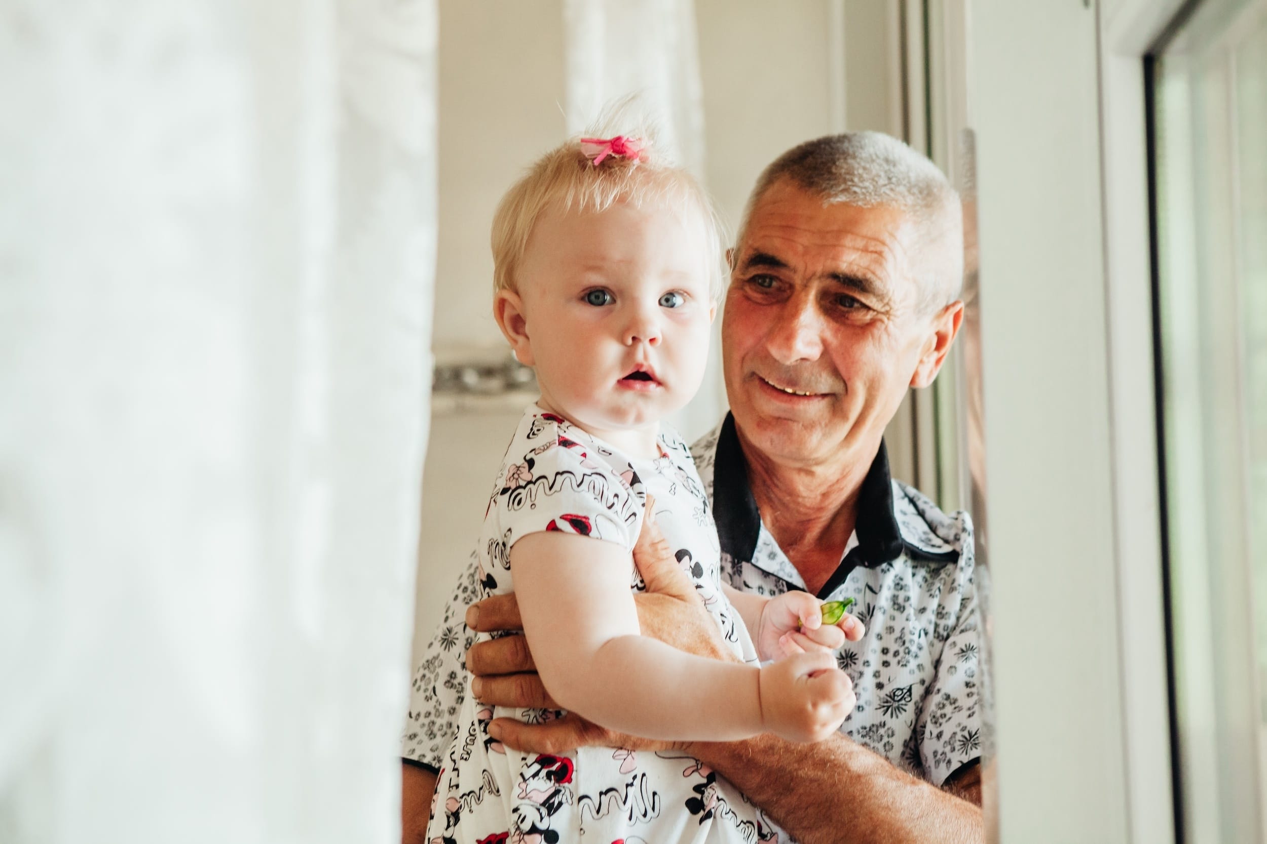 a grandfather holding hs granddaughter