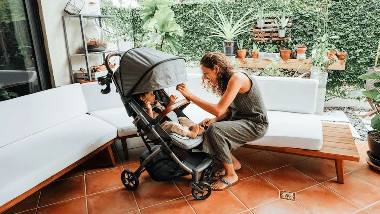 mom playing with baby in a stroller