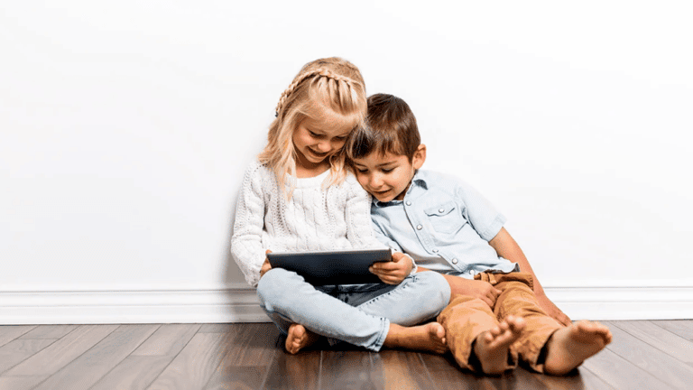 two kids watching something on a tablet