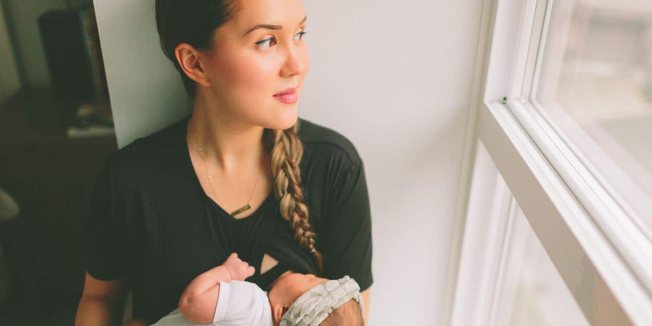 mother holding baby while feeding