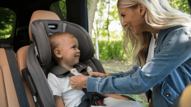 mom putting baby in a car seat