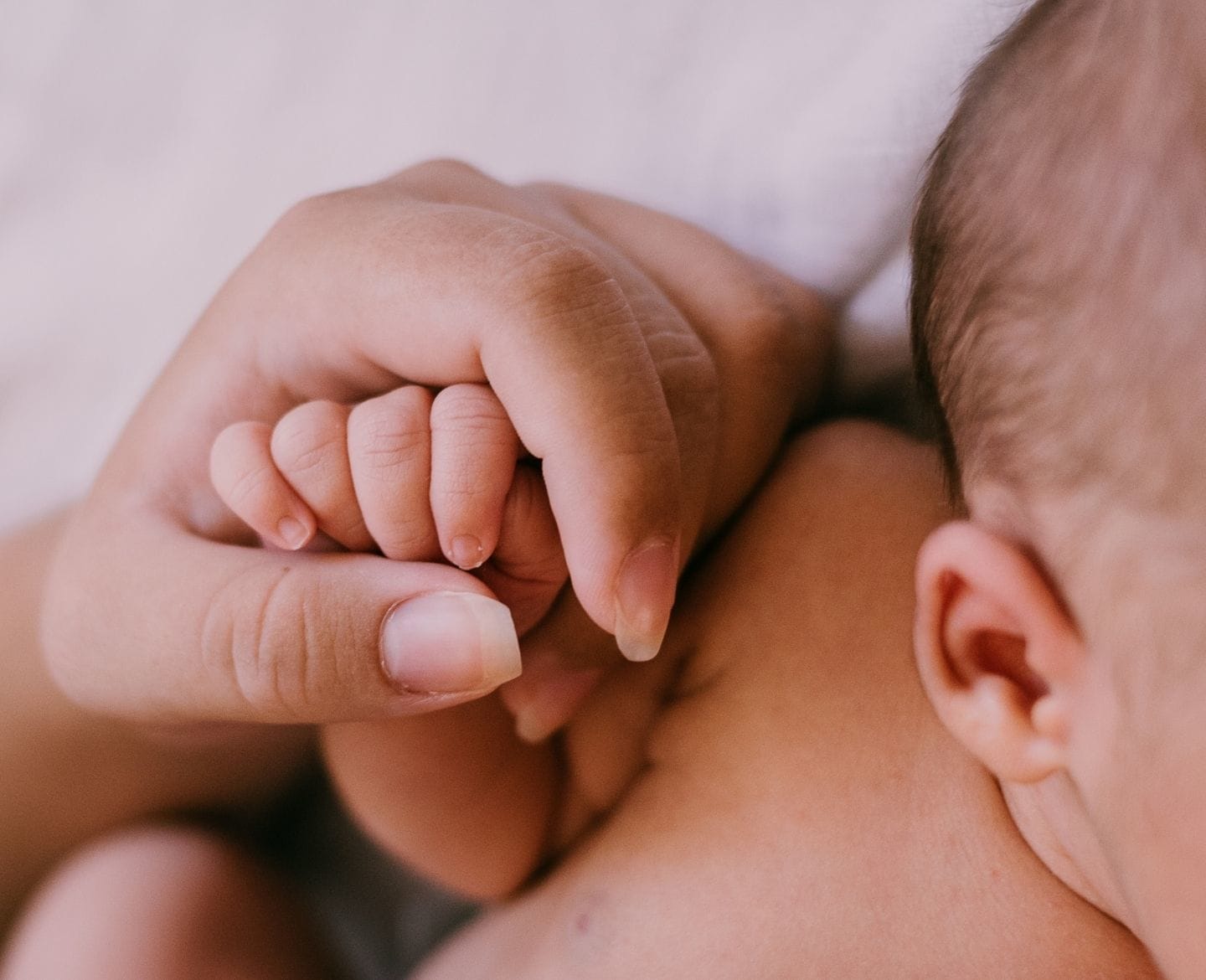 close up of mom holding baby's hand