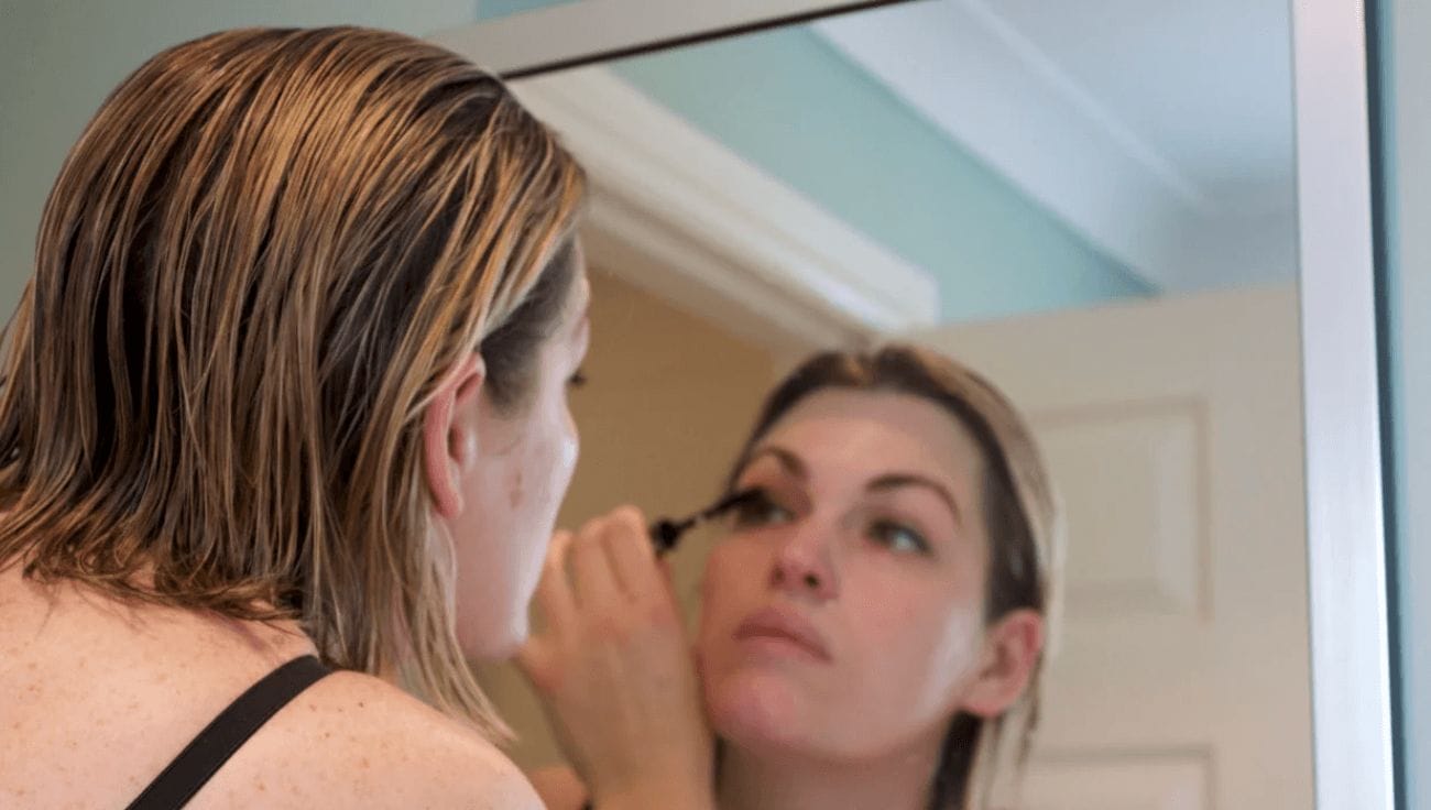 woman putting on mascara