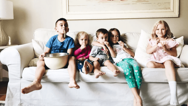 kids on the couch watching a movie and eating snacks