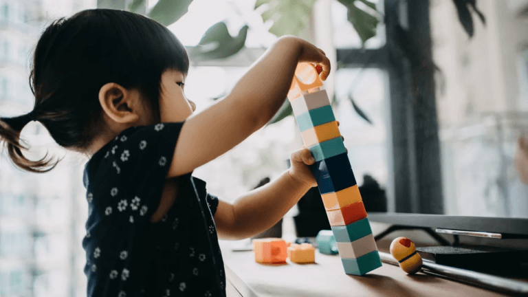 little girl playing with stacking blocks