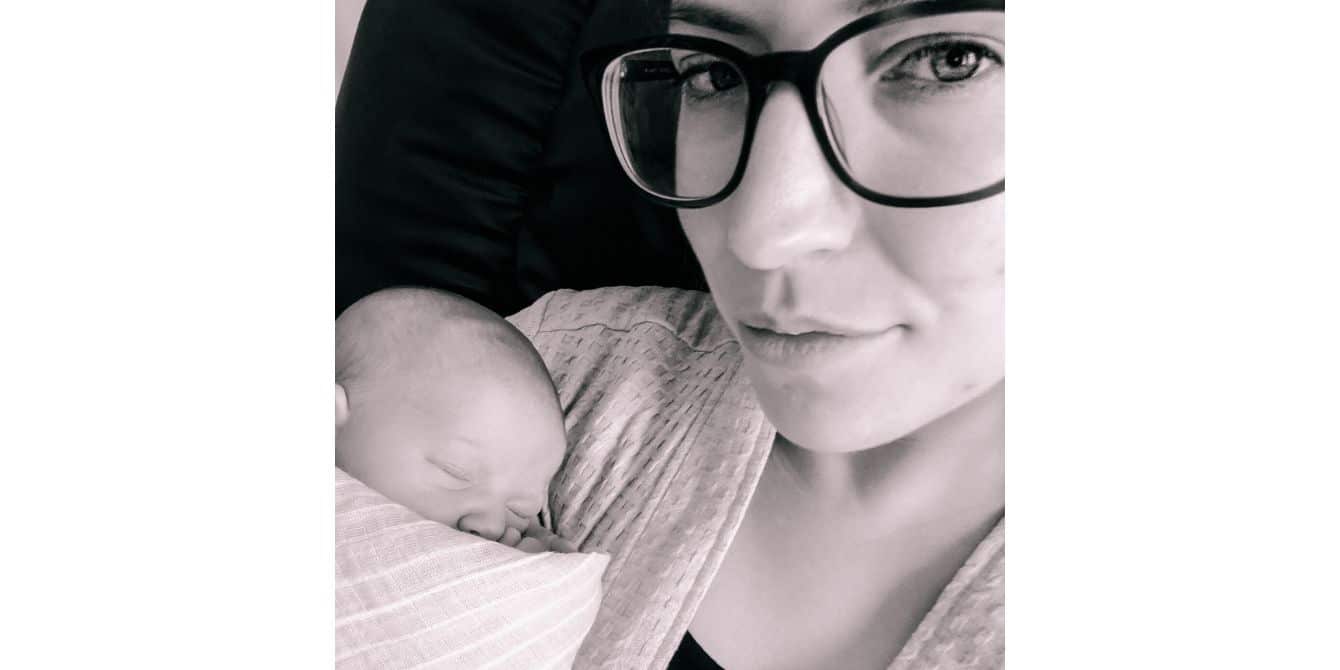 selfie of a mom holding a newborn baby - essay on surviving postpartum depression