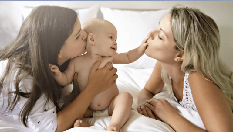 woman hold baby and another woman kissing baby's hand