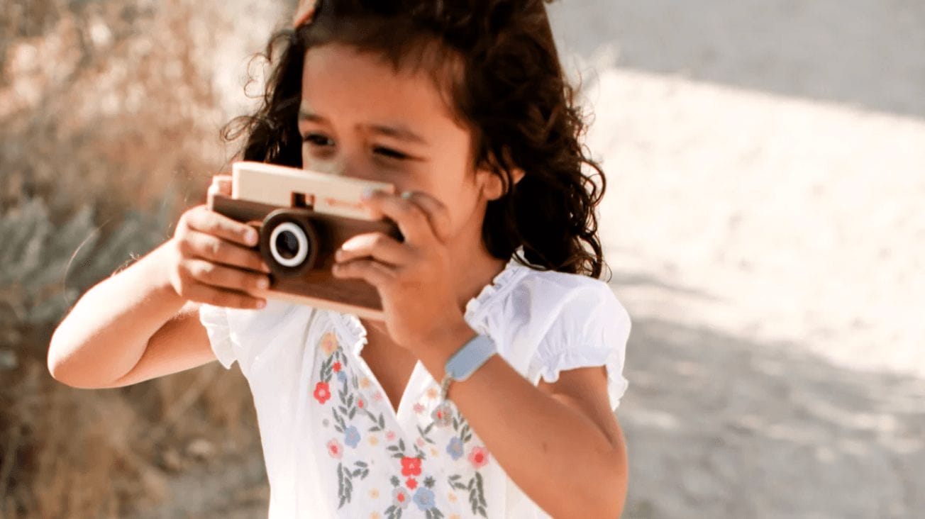 child taking a picture with a camera