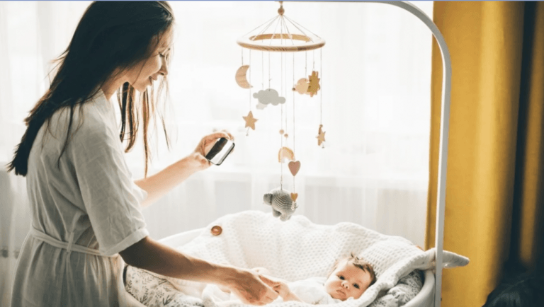 mom taking a picture of a baby in her bassinet