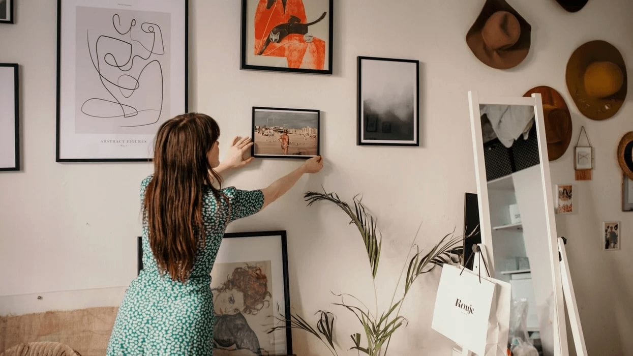 woman hanging up a gallery wall