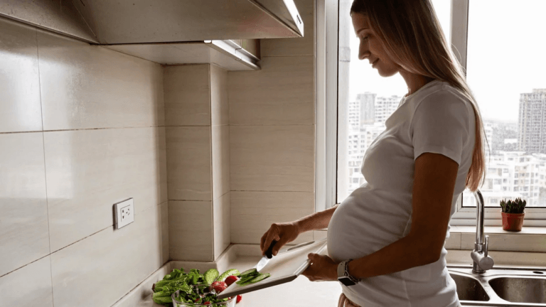 pregnant woman cooking with vegetables