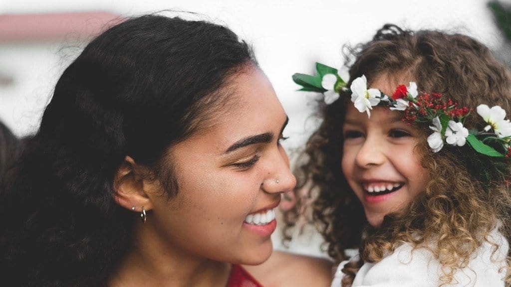 mom smiling at daughter wearing a flower crown - empowering phrases for daughters