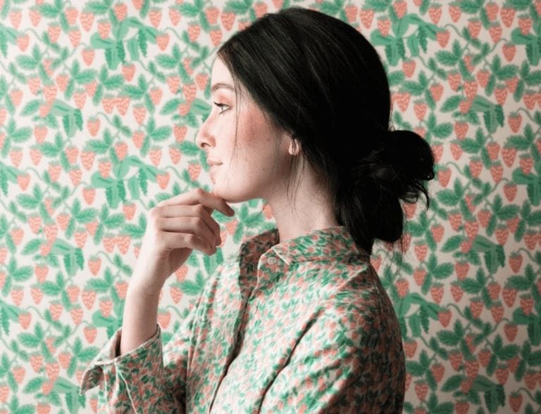 woman standing in front of wallpaper wearing a matching shirt