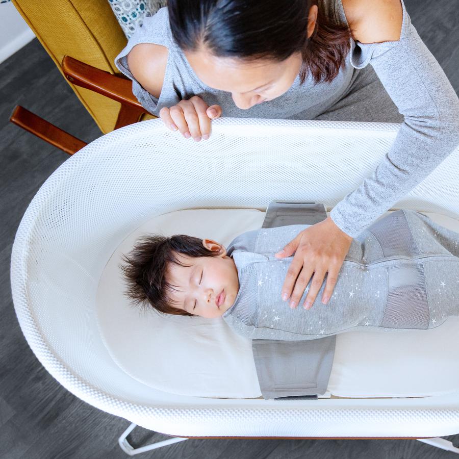 mom watching a baby sleep in a snoo - shop the snoo sale