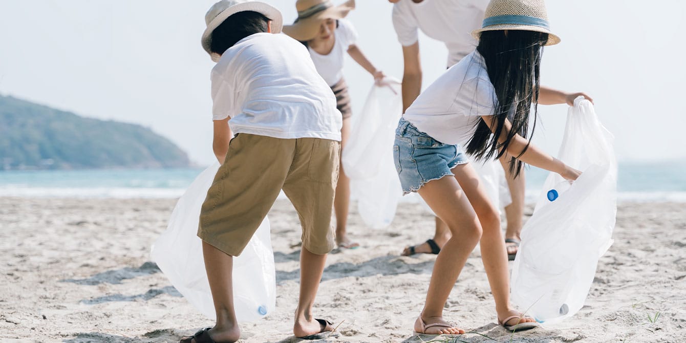 family picking up trash on the beach- random acts of kindness