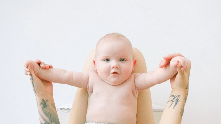 little baby held up by moms arms