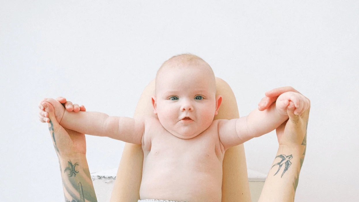 little baby held up by moms arms