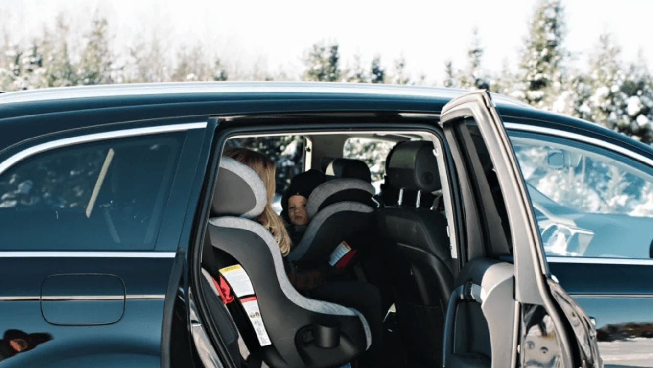 mom putting baby in a car seat