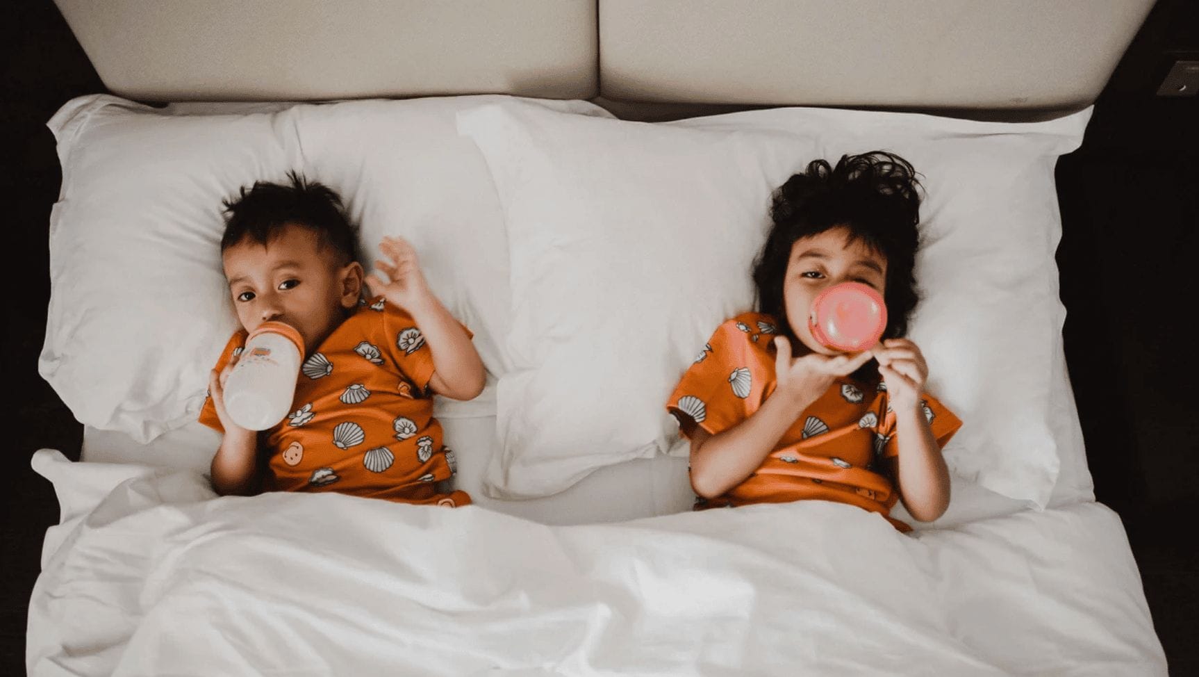 two kids laying in bed- baby's sleep schedule