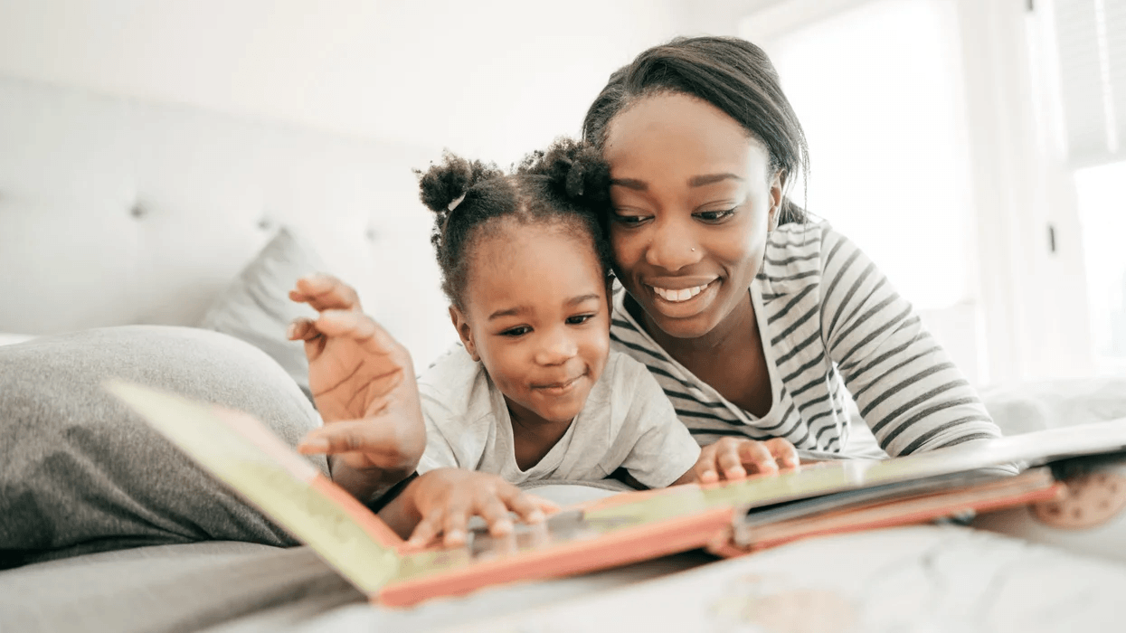 mom reading with daughter in bed