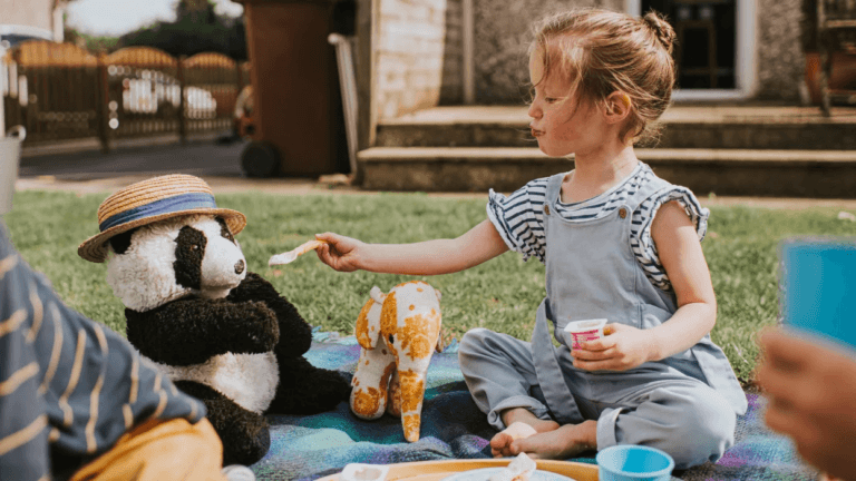 little girl having a teddy bear picnic