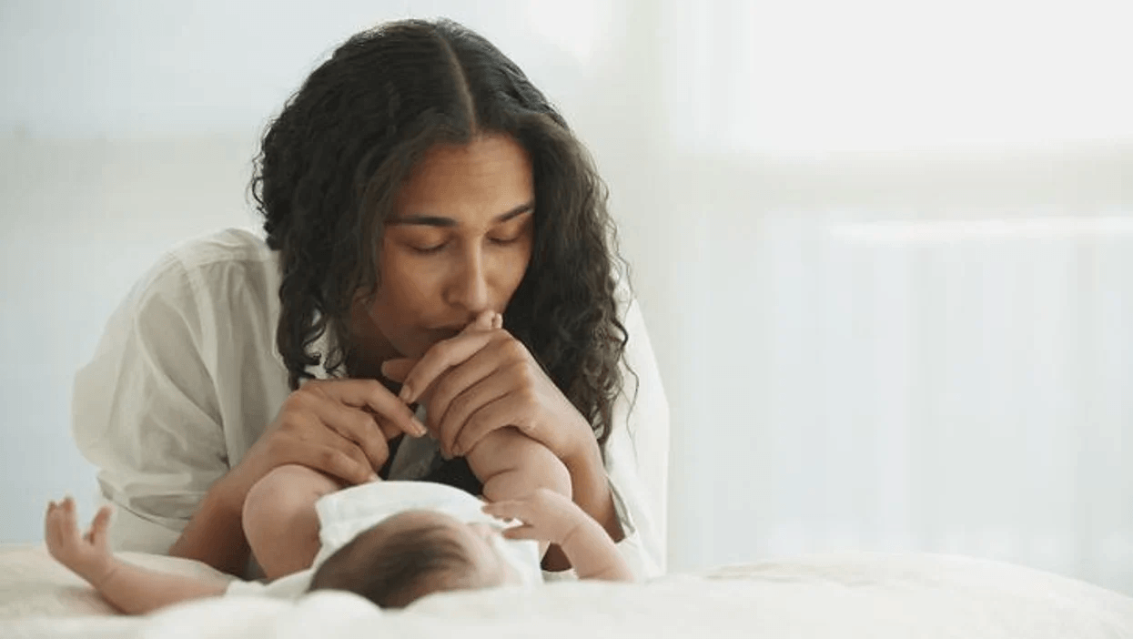 mom kissing baby's feet because she knows what to expect during a c-section