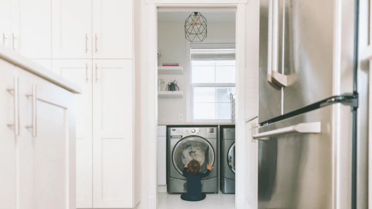 kid sitting in front of a washing machine