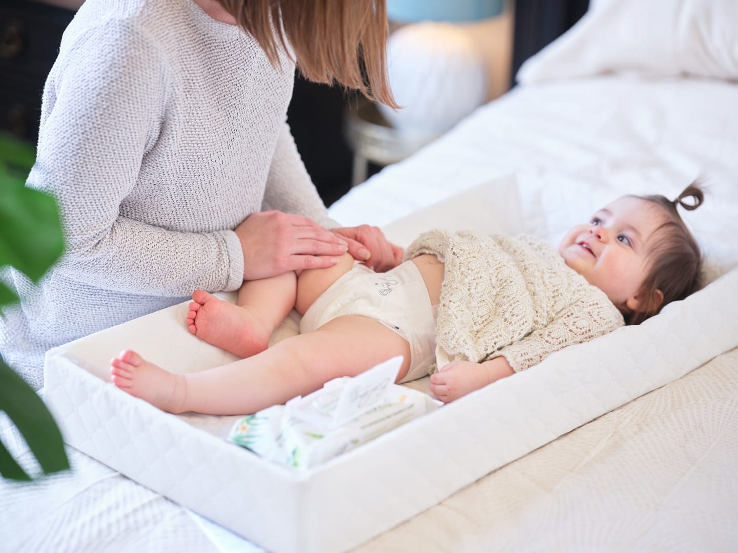 mom changing a baby's daiper - best natural baby wipes