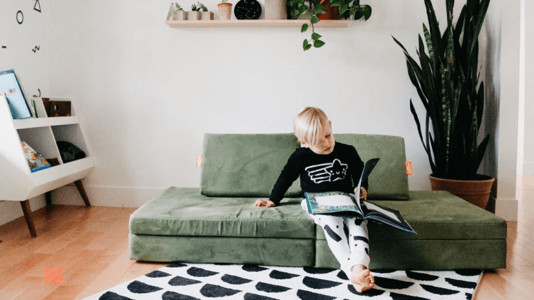 little boy reading on a nugget couch