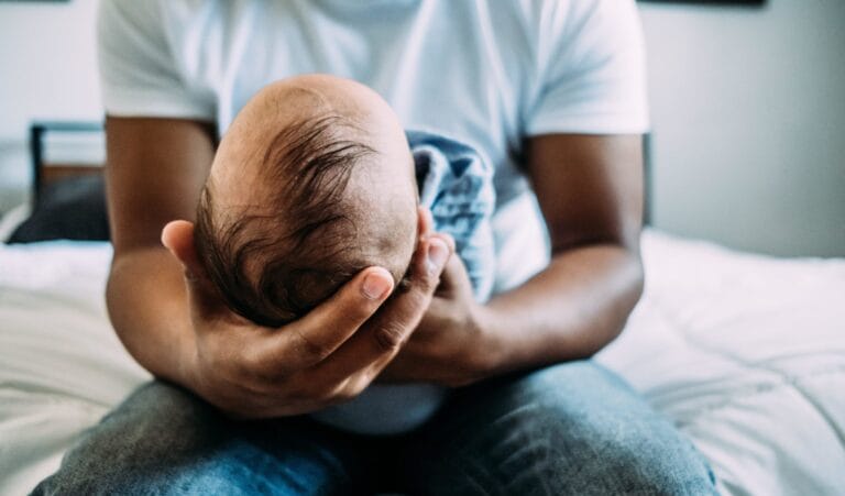 dad holding newborn baby contemplating foods that increase sperm count